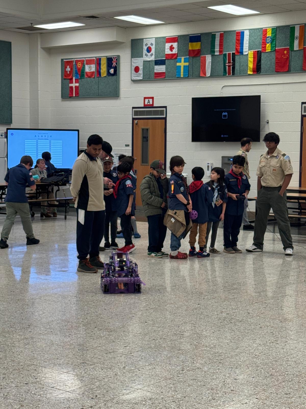 Younger Scouts gather behind a BeaverBots robot during a community FIRST awareness demonstration.