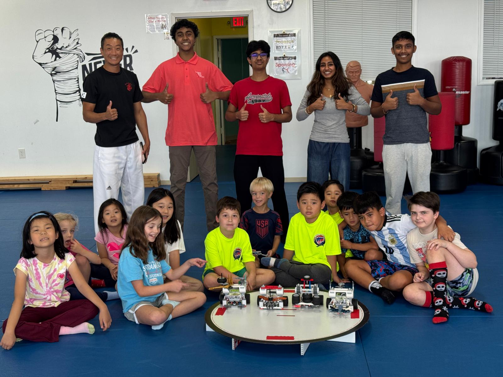 SugoBot Day Camp participants and mentors gather with several completed robots.